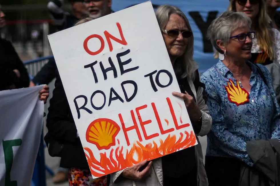 Surrounded: A climate activist holds a placard outside ExCeL, in London, during Shell's Annual General Meeting in May.