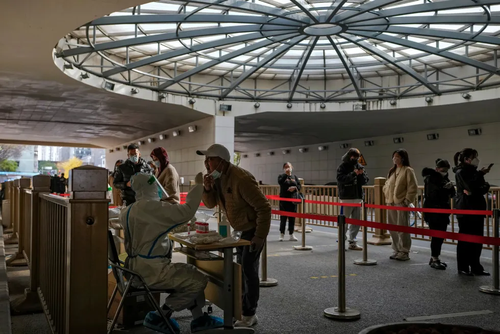 Masked; People stand in line for their routine COVID-19 tests at a coronavirus testing site setup at a tunnel in the central business district of Beijing
