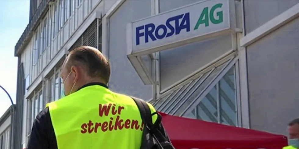 A worker on strike outside German seafood company Frosta's facility in Bremerhaven.