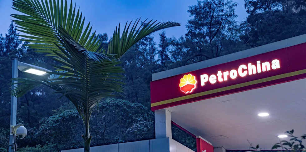 Signage for PetroChina Co. is illuminated atop a gas station at dusk in Hong Kong, China.