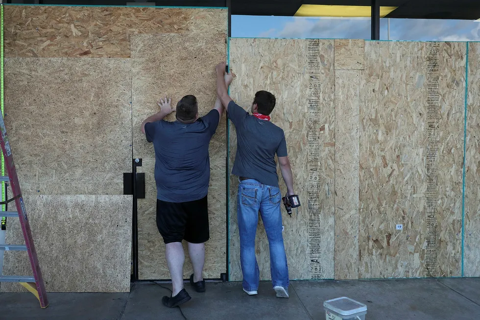 Battoning down: two men work on placing plywood over the windows of a business before the arrival of Hurricane Laura on 25 August, 2020 in Lake Charles, Louisiana