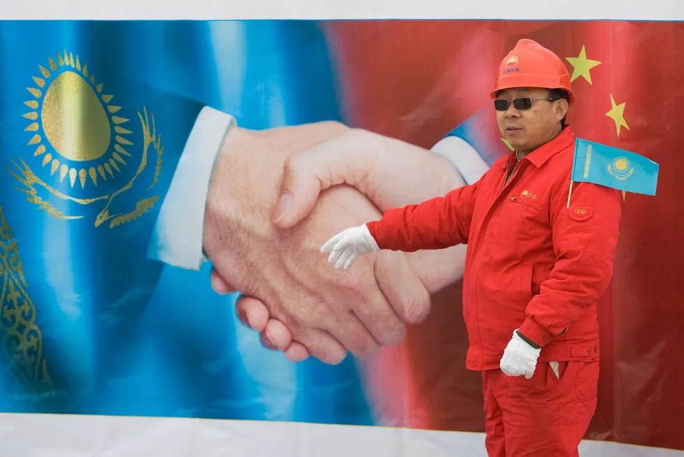 A Chinese worker stands in front of a poster during the 2009 inauguration ceremony of the Kazakhstan segment of the Turkmenistan-Kazakhstan-China gas trunkline at Otar gas station about 130 kilometres from Almaty.