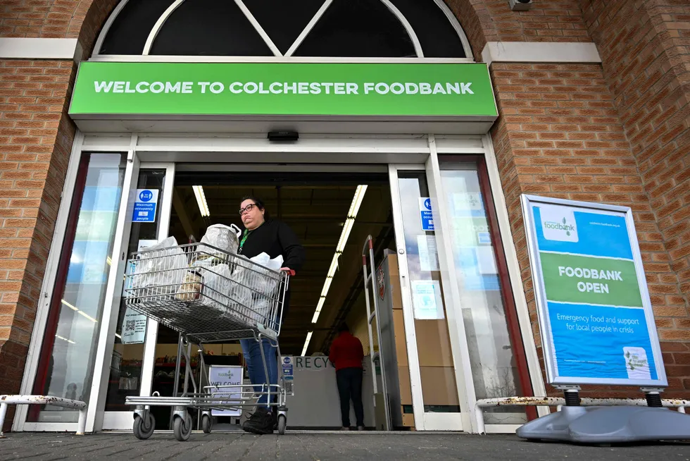 Cost-of-living crisis: A woman pushes a trolley of donated goods from the Colchester Foodbank in England. Foodbank use is soaring in the UK as rising energy costs force people to choose between heating or eating during winter.