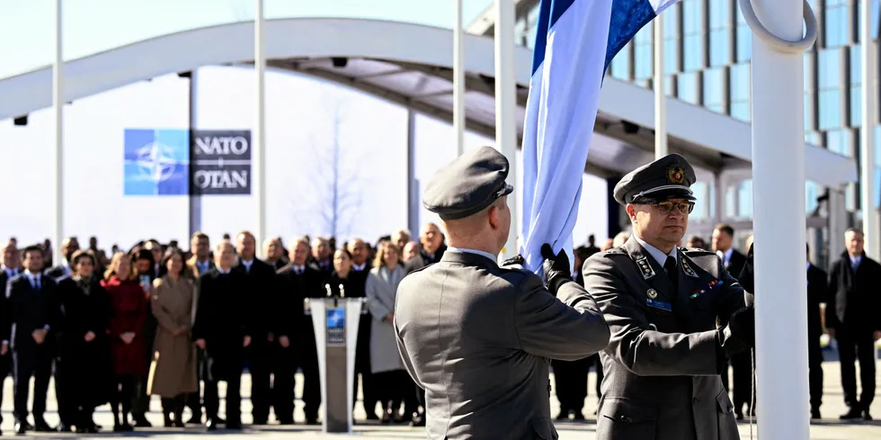 Finnish military personnel install the national flag at the NATO headquarters in Brussels, on April 4, 2023.