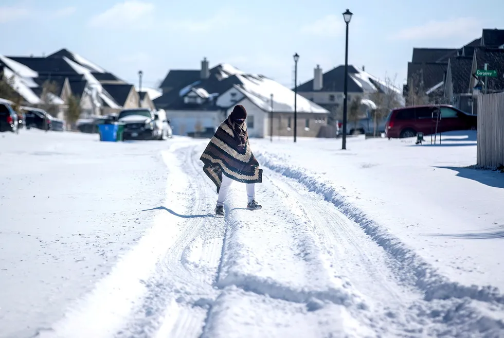 Big freeze: a man walks in a neighbourhood without electricity as snow covers the BlackHawk neighborhood in Pflugerville, Texas