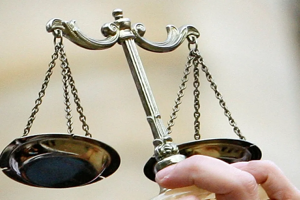 A lawyer holds the scales of justice as she takes part in a demonstration of lawyers in front of the Paris courthouse, Thursday, Jan. 14, 2010 in Paris. . .