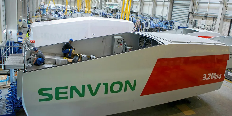 Employees assemble a Senvion wind turbine nacelle in Bremerhaven