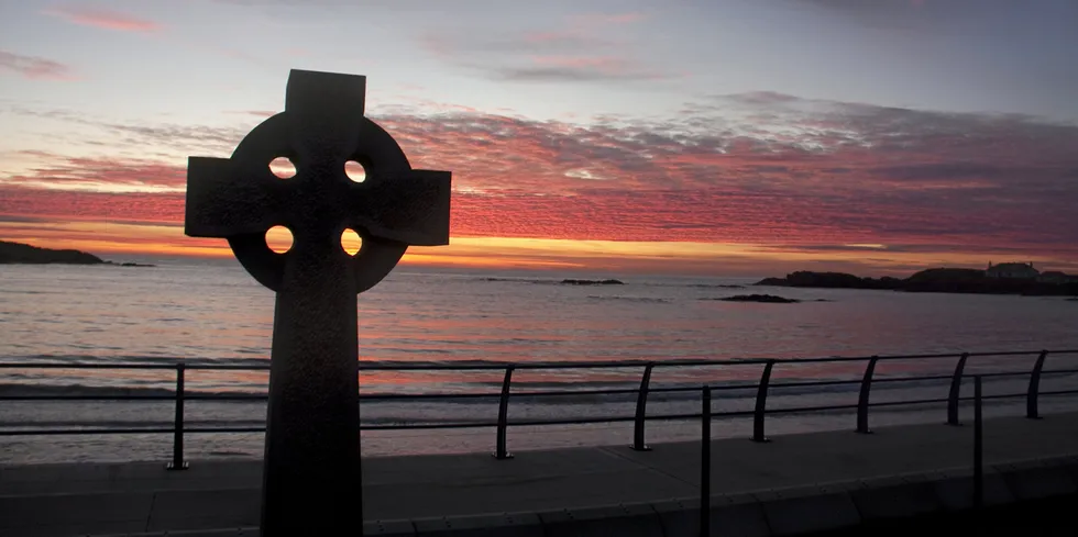 Celtic cross at sunset looking out to the sea from Wales,