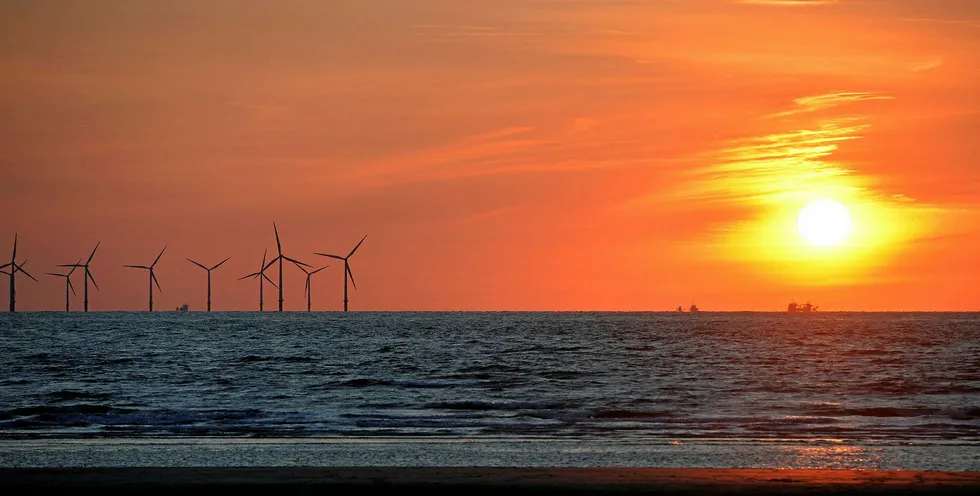 The sun sets beside the Burbo Bank wind farm in the Irish Sea