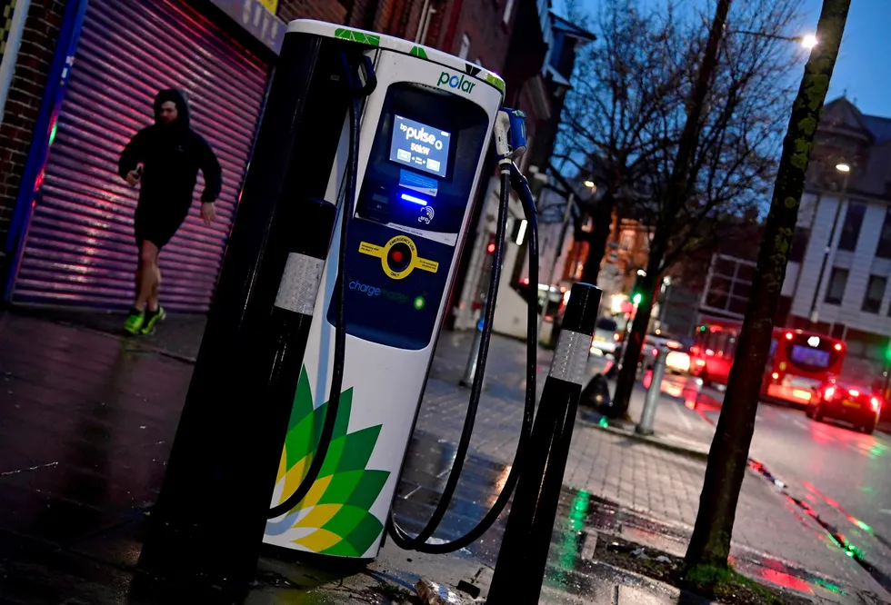 Electric: a man runs past a BP electric Vehicle charging point in London