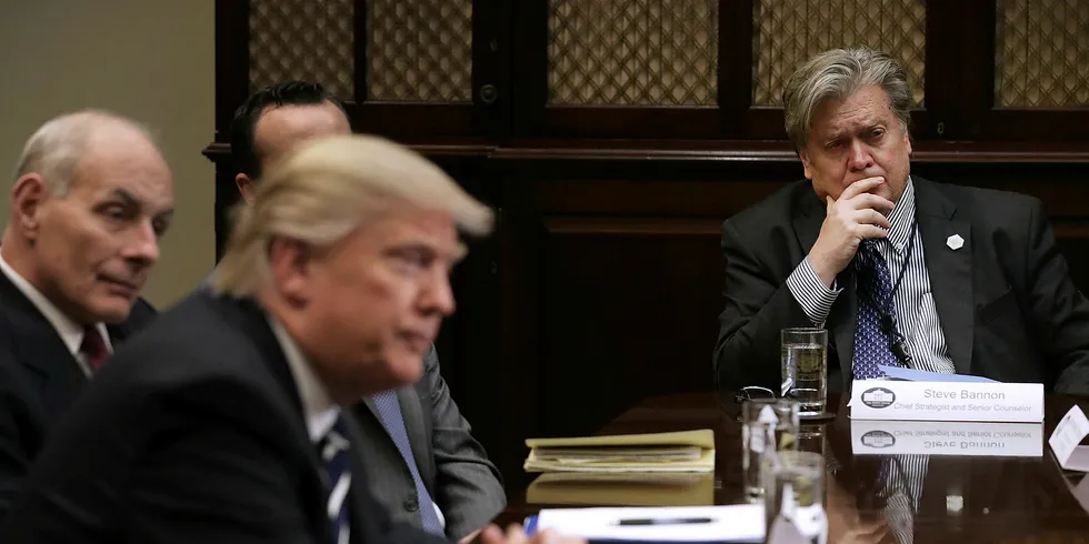 White House chief strategist Steve Bannon (R) listens to Donald Trump.