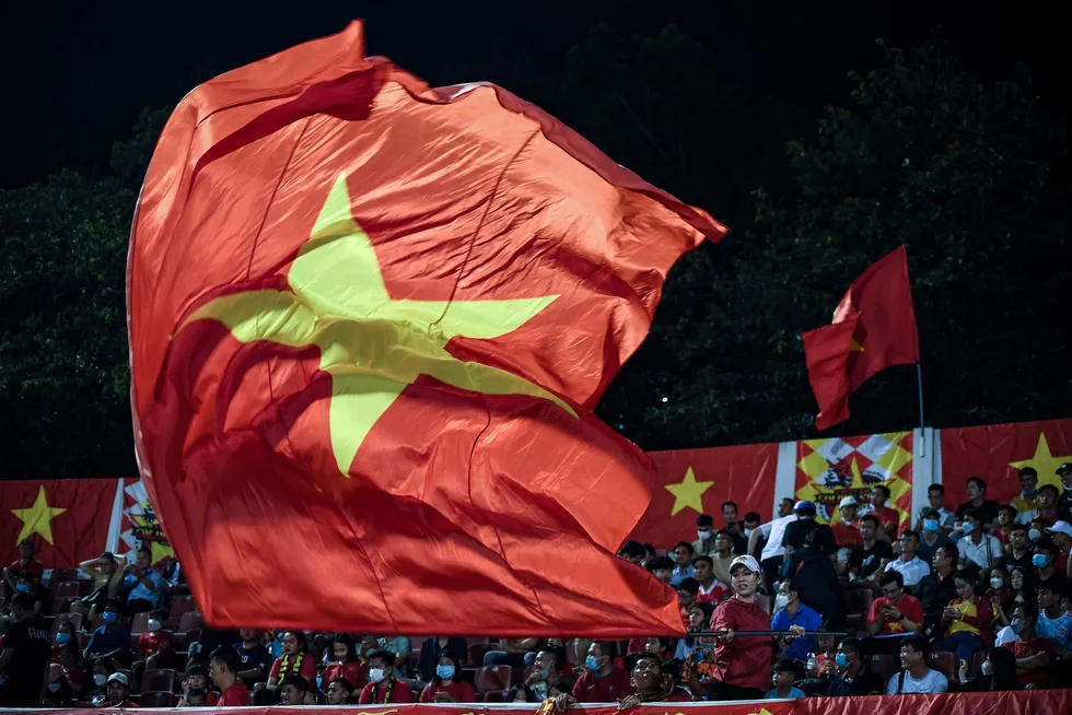 A supporter waves a giant flag of Vietnam before the Hung Thinh International Football Tournament 2022 friendly football match between Vietnam and Singapore.