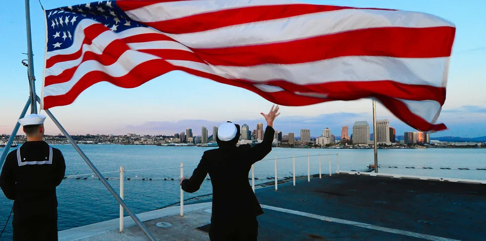 Sailors lower the US flag aboard the aircraft carrier USS Ronald Reagan at the naval base in Coronado, California