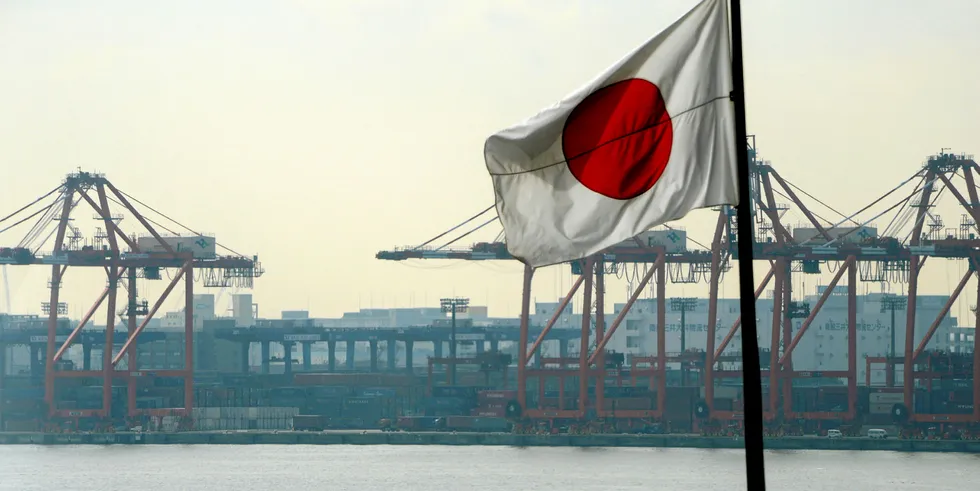 The Japanese national flag flies in front of the container pier in Tokyo port