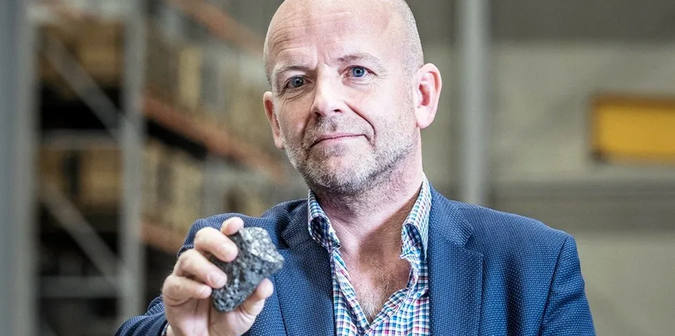 Boson Energy CEO Jan Grimbrandt holding up a lump of 'IMBY' rock produced as a by-product of the company's innovative hydrogen production process.
