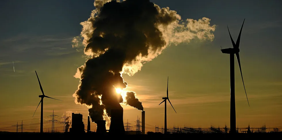 Wind turbines stand beside the RWE Niederaussem coal-fired power plant near Bergheim, Germany.
