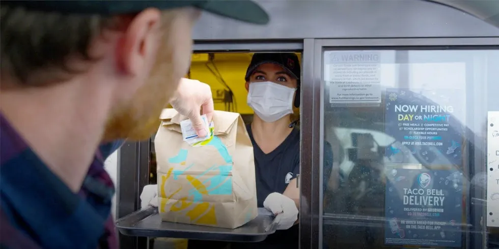A diner picks up food at a drive-through restaurant.