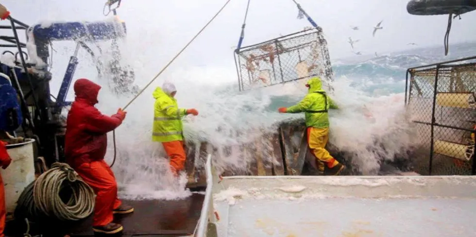 Alaska crab fishermen haul in a pot in rough waters.