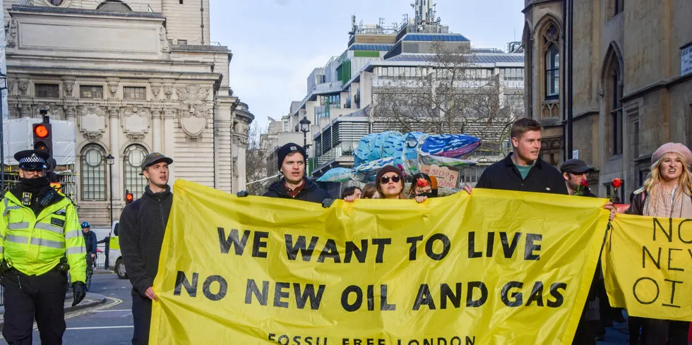 Protesters march with an anti-fossil fuel banner.