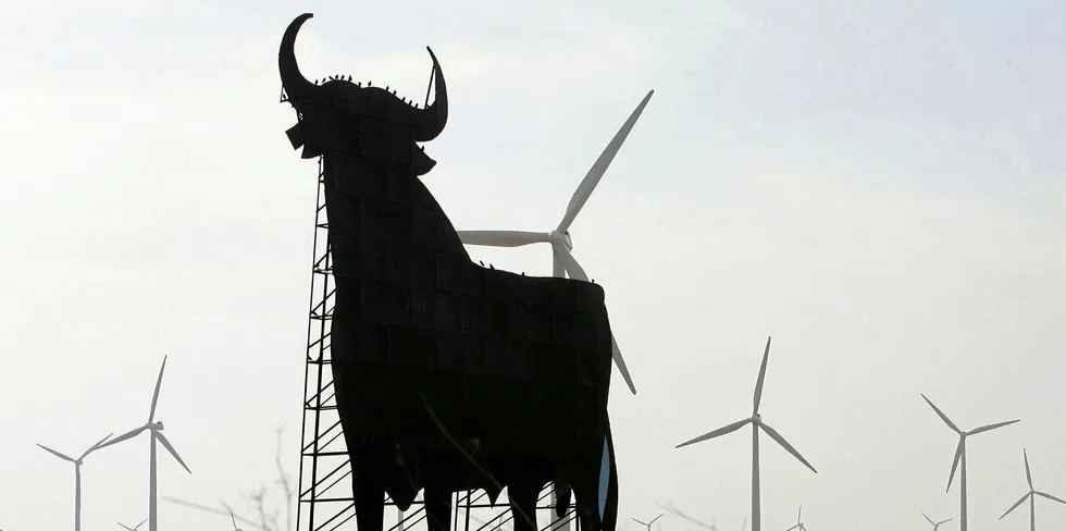 An Osborne bull is by range of windturbines in La Muela near Zaragoza.