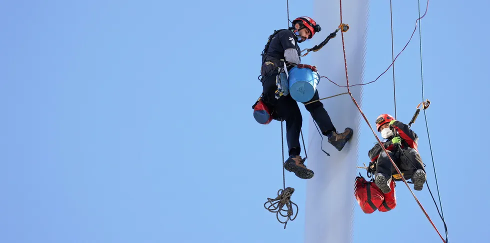 IZMIR, TURKEY - FEBRUARY 19: Rope access technicians carry out maintenance service on wind turbines including repairs, blade inspections and cleaning in Izmir, Turkey.