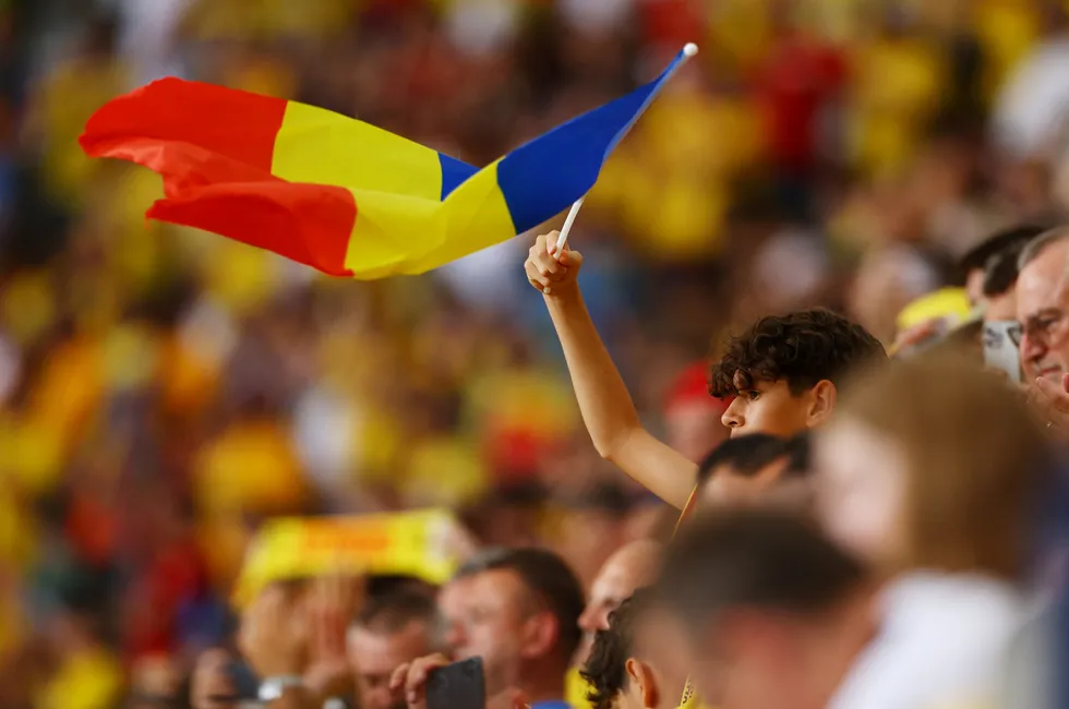 A Romania fan waves country's flag at a football match in 2024.