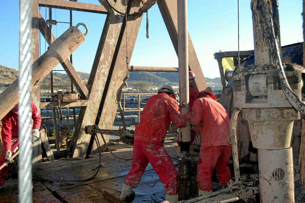 Connection: workers on a rig in China's Ordos basin
