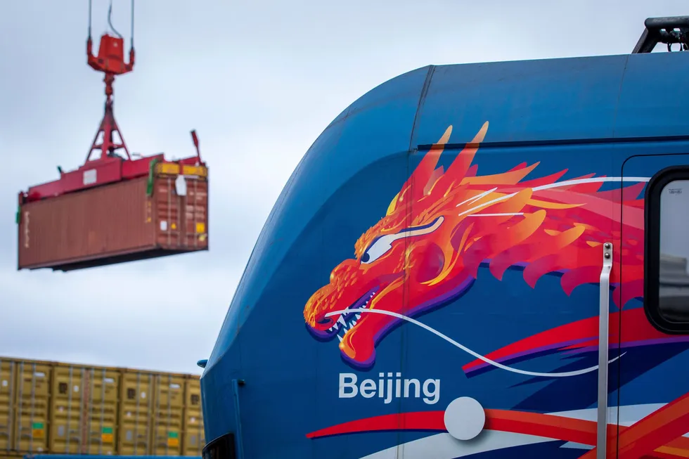 A container with Chinese goods is loaded behind a locomotive in China.
