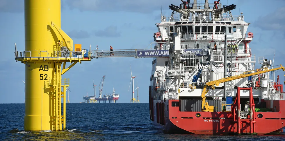 Workers cross to a wind turbine at Arkona project in German Baltic Sea