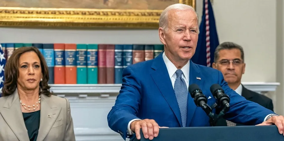 US President Joe Biden (center) speaks at a White House event. Vice President Kamala Harris stands at left. Biden has proposed expanding SIMP.
