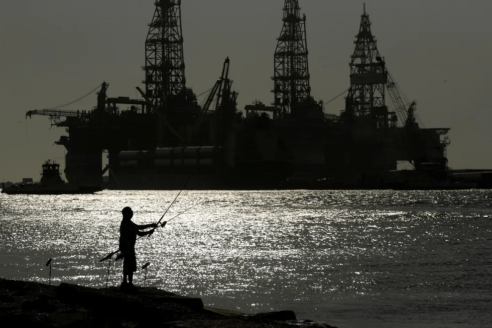 Catch: A man fishes near docked drilling platforms in the Gulf of Mexico off the coast of Texas