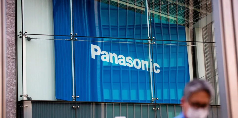 A man walks past a Panasonic building in Tokyo.