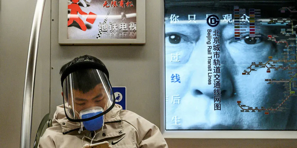 A Chinese man wears a protective mask and face shield as he rides the subway during rush hour on February 14, 2020 in Beijing, China.