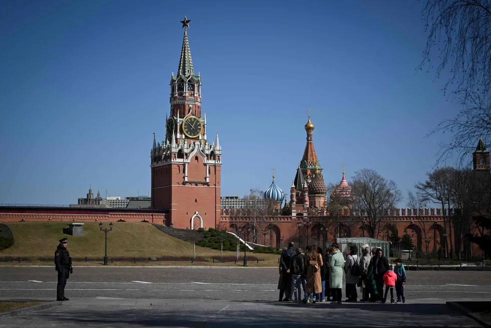 Rouble retreat: a law enforcement officer stands guard as people tour the grounds of the Kremlin.