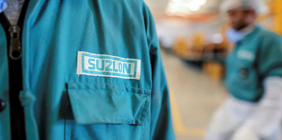 The Suzlon Energy Ltd. logo is displayed on an employee's uniform at the company's rotor blade manufacturing plant in Bhuj, India.
