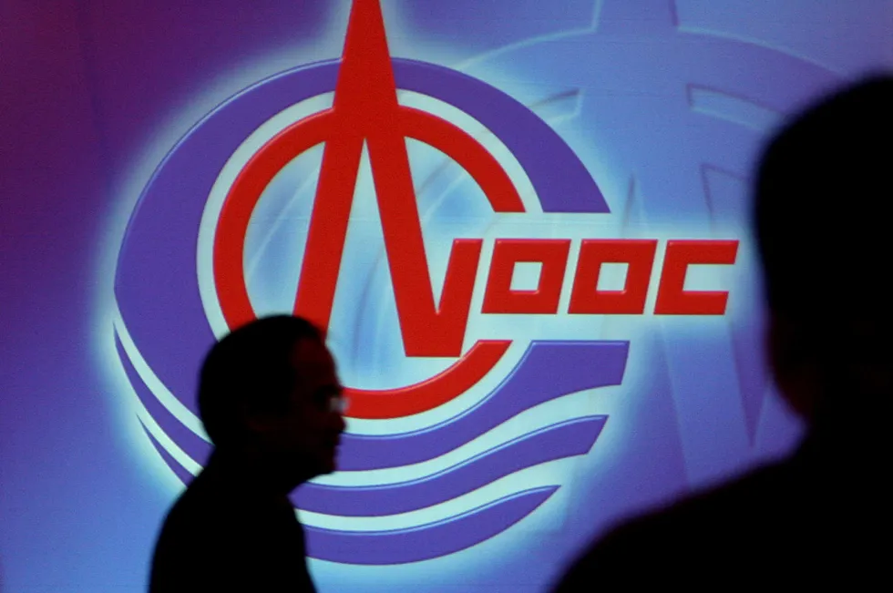 A man walks past the logo of CNOOC Ltd in Hong Kong. The company has taken delivery of the hydraulic fracturing equipment for its first offshore fracking vessel, Hai Yang Shi You 696.