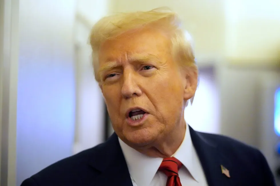 US President Donald Trump speaks to reporters aboard Air Force One on Monday.
