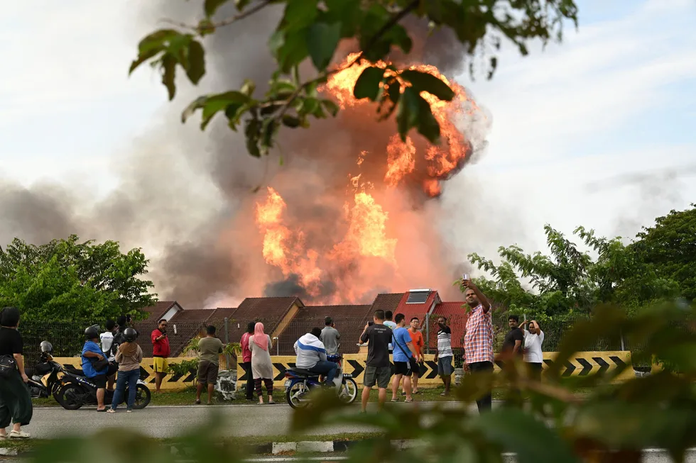 Residents watch the fire from Petronas' ruptured gas pipeline in Putra Heights in Selangor state, Malaysia, on 1 April 2025.