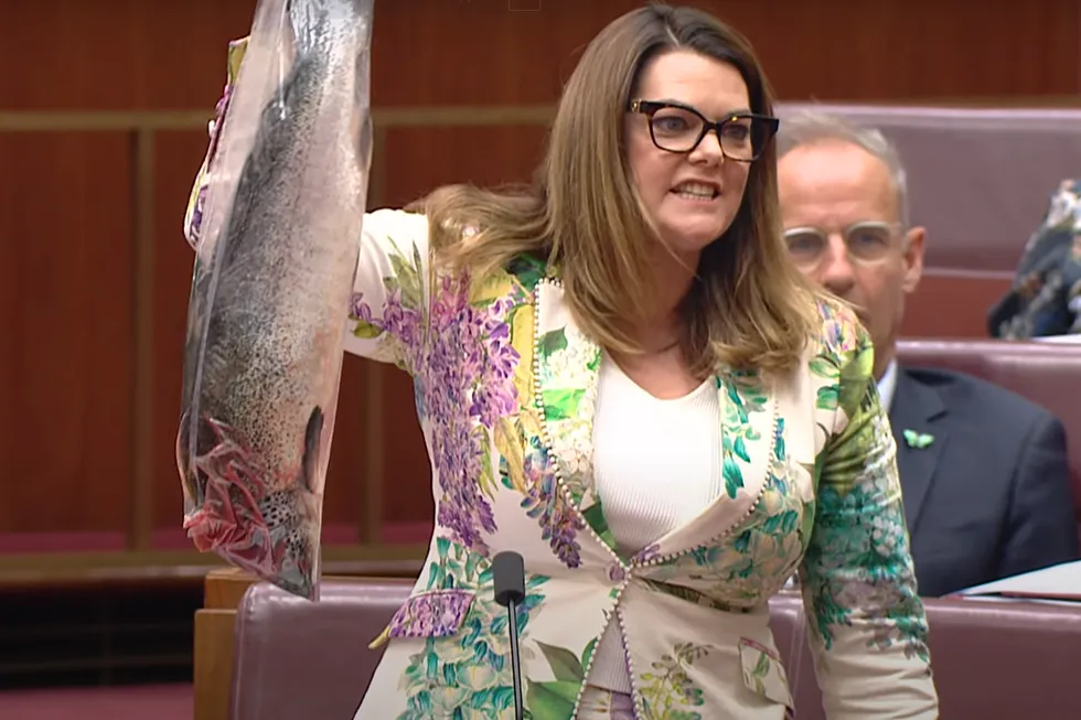 Australian Green Party Environment Spokesperson Sarah Hanson-Young waves a dead salmon in parliament.