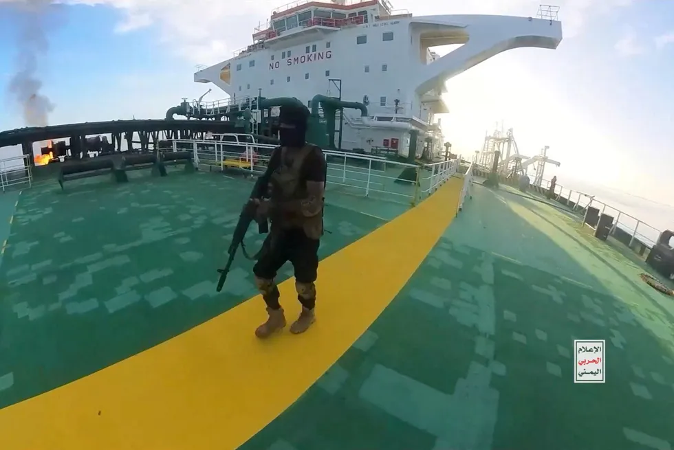 A Houthi fighter strides along the deck of the Sounion.