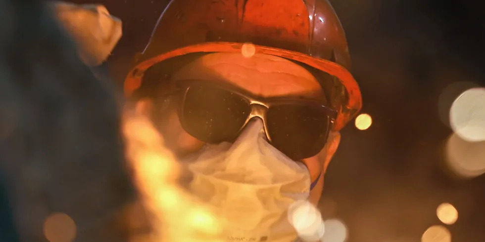 A steelmaker pours pig iron from a blast furnace, sparks and splashes of hot metal fly. . Steel.