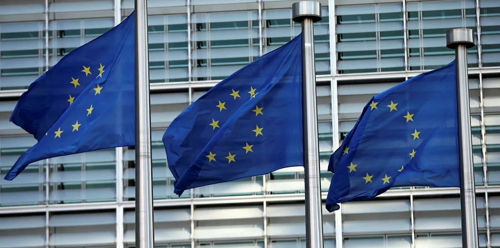 EU flags fly outside the European Commission headquarters building.