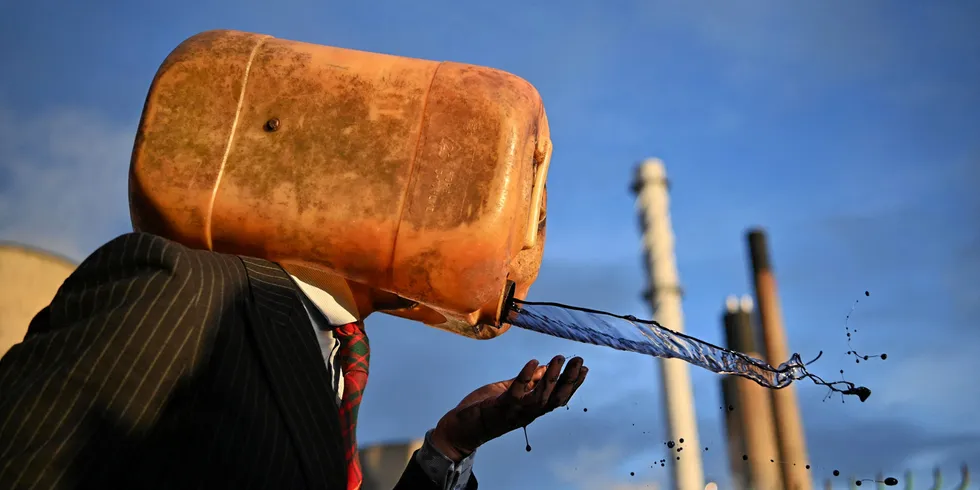 A climate activist from the Ocean Rebellion group vomits mock oil as they demonstrate during COP26.