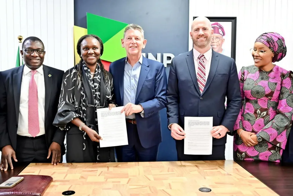 Oritsemeyiwa Eyesan, NNPC's head of upstream (centre left) and Liam Mallon, ExxonMobil's upstream president (centre) with a signed settlement agreement.