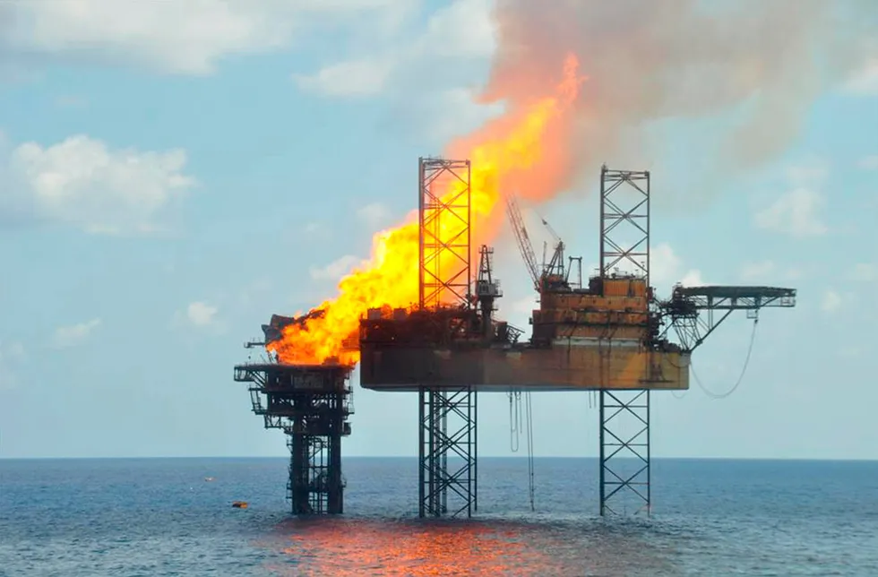 Ablaze: the Montara wellhead platform (left) and the jack-up West Atlas offshore Australia, in 2009.