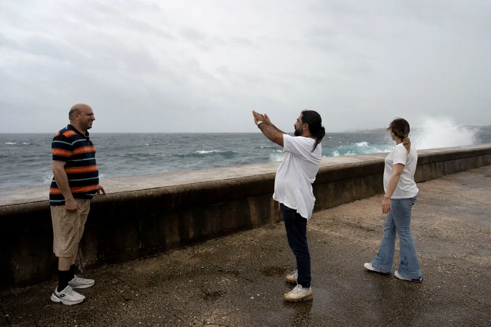 Tourists from Iran take pictures at the seafront Malecon as Hurricane Rafael approaches Havana, Cuba, on Wednesday, 6 November 2024.