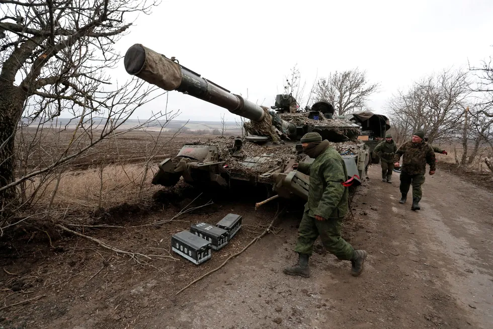 Invasion: pro-Russian separatists walk near an abandoned tank on a road between the separatist-controlled settlements of Mykolaivka (Nikolaevka) and Buhas (Bugas), as Russia's invasion of Ukraine continues