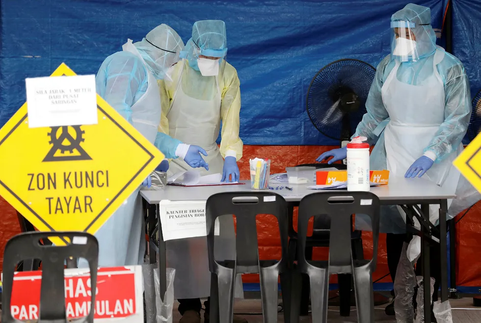 Testing for Covid-19: health workers in protective suits at a clinic in the Malaysian capital Kuala Lumpur on 23 March