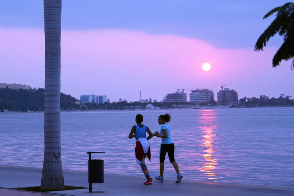 Moving ahead: locals on the beach during sunset in the Angolan capital, Luanda