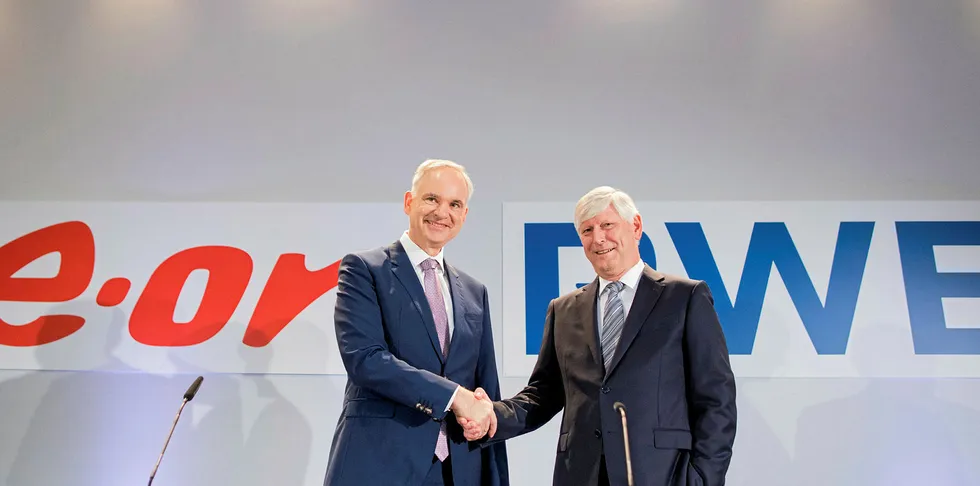 Johannes Teyssen, chief executive of E.ON (left) shakes hands with RWE chairman Rolf Martin Schmitz at a press conference to announce the deal in March last year.